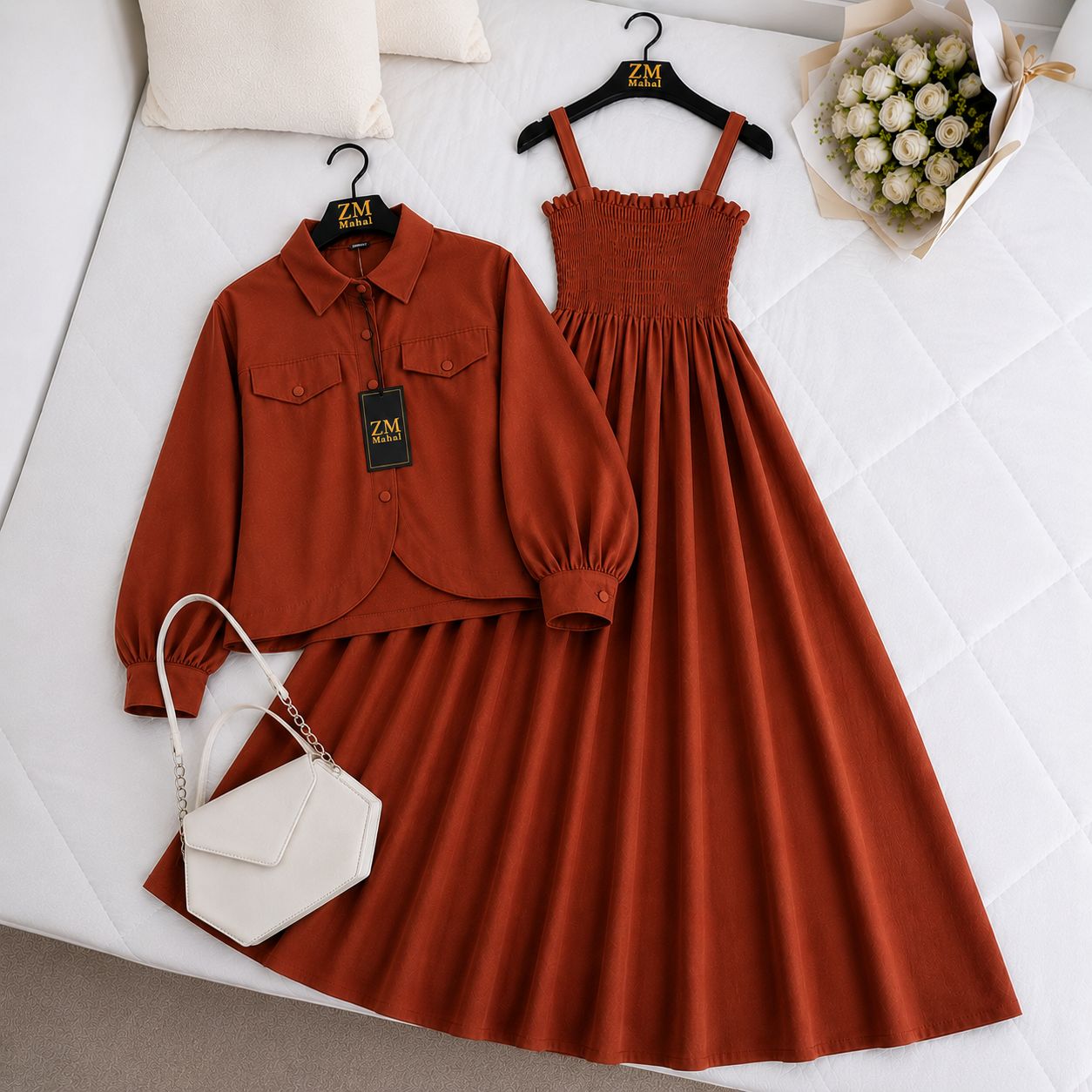 Brown dress, blouse, and white handbag on a white surface with 'ZM' branding.
